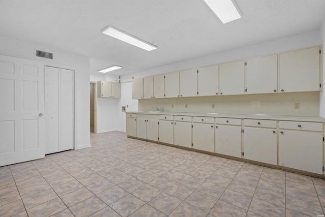 1200 Rock Creek Rd, Hot Springs, AR 71913 - kitchen with cream cabinets, light countertops, baseboards, and a sink
