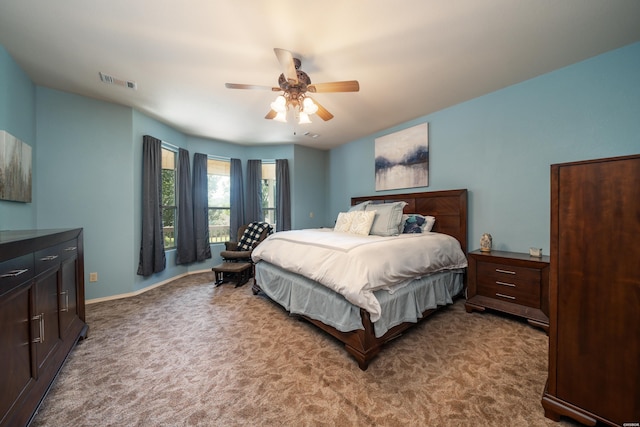 bedroom with ceiling fan, baseboards, visible vents, and light colored carpet