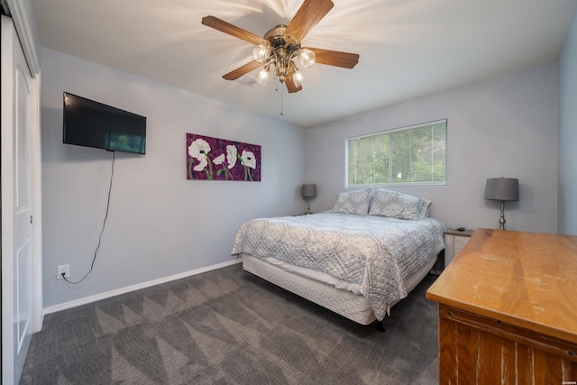 bedroom with ceiling fan, dark carpet, and baseboards