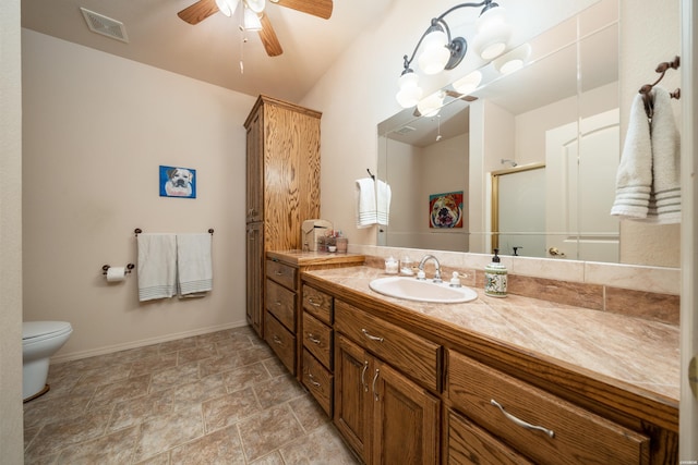 bathroom with visible vents, toilet, a ceiling fan, vanity, and baseboards