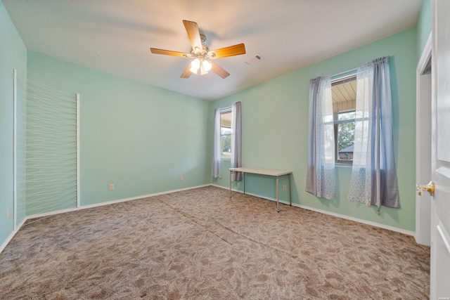 unfurnished room featuring a ceiling fan, carpet, visible vents, and baseboards