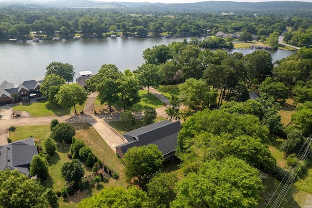 birds eye view of property with a water view and a wooded view