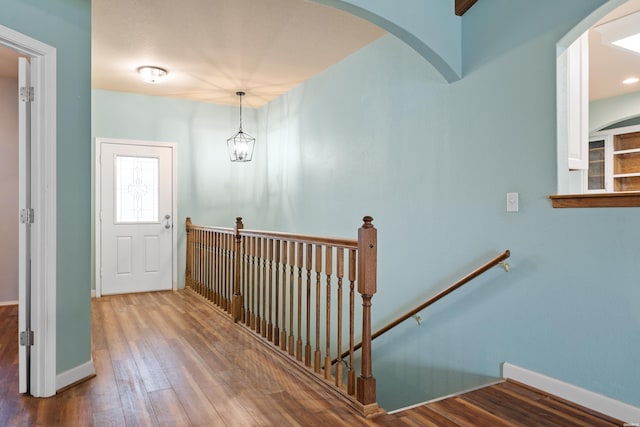 entrance foyer featuring a notable chandelier, baseboards, and wood finished floors