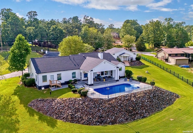 exterior space with a patio, a lawn, fence, and an outdoor living space