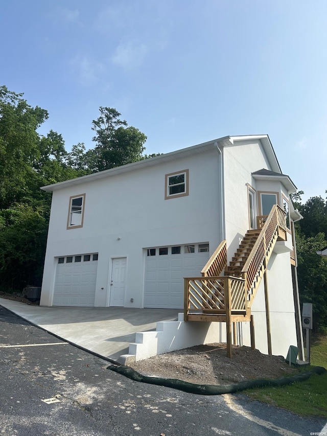 208 Aberina Unit G, Hot Springs, AR 71913 - view of property exterior with stucco siding, an attached garage, and stairway