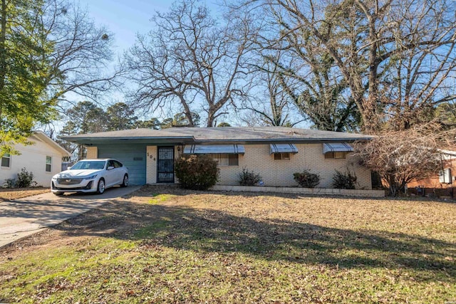 ranch-style home with a front yard, concrete driveway, and brick siding