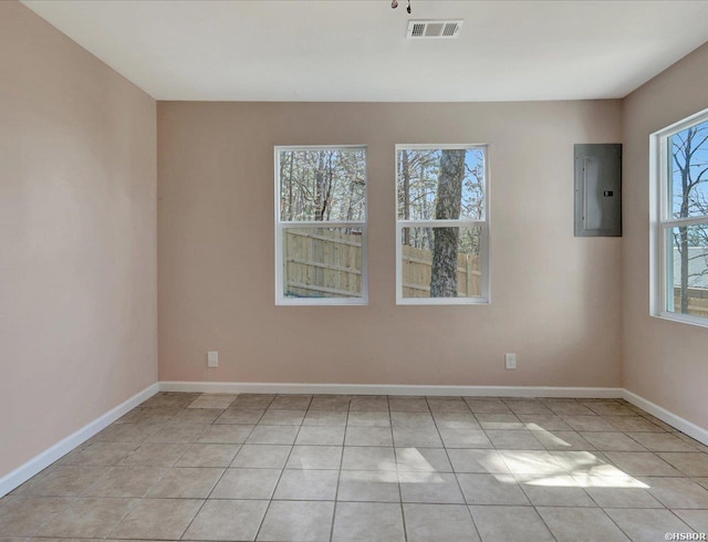 unfurnished room featuring electric panel, visible vents, baseboards, and light tile patterned floors