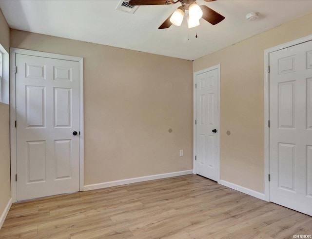 unfurnished bedroom with ceiling fan, light wood-style floors, visible vents, and baseboards