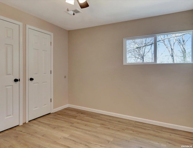 unfurnished bedroom with ceiling fan, visible vents, baseboards, and light wood-style flooring