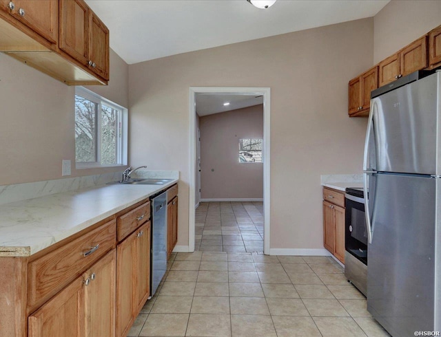 kitchen featuring light tile patterned flooring, plenty of natural light, a sink, light countertops, and appliances with stainless steel finishes