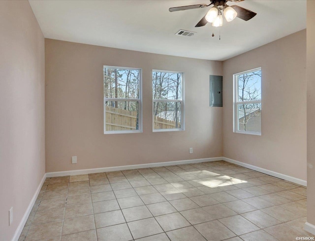 spare room with light tile patterned floors, baseboards, visible vents, electric panel, and ceiling fan