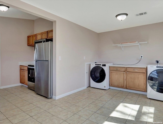 washroom featuring light tile patterned floors, laundry area, washer / clothes dryer, and visible vents