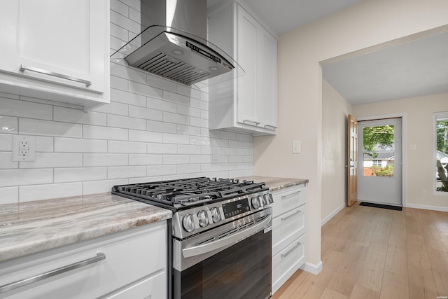 106 Grissom Trl, Hot Springs, AR 71913 - kitchen featuring gas stove, wall chimney exhaust hood, baseboards, white cabinets, and light stone countertops