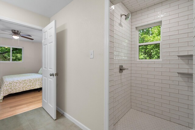 106 Grissom Trl, Hot Springs, AR 71913 - ensuite bathroom featuring tiled shower, a ceiling fan, tile patterned flooring, and baseboards