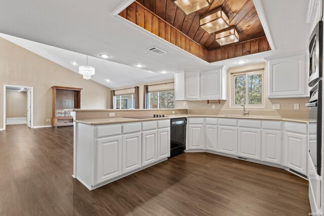 kitchen featuring light countertops, hanging light fixtures, white cabinetry, a sink, and a peninsula