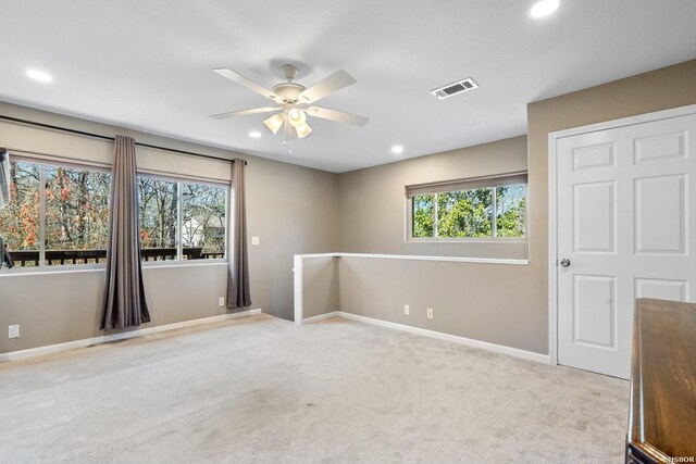 unfurnished room with ceiling fan, recessed lighting, light carpet, visible vents, and baseboards