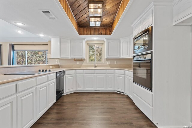 kitchen with light countertops, white cabinetry, visible vents, and black appliances