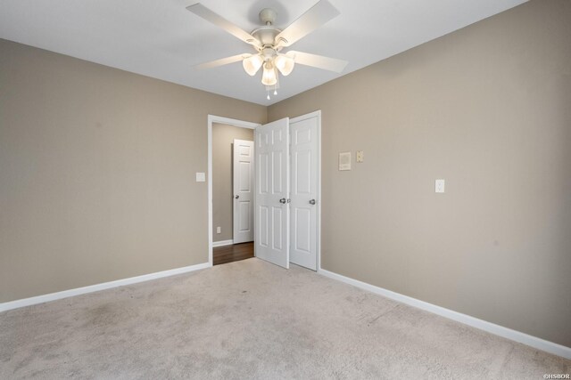 spare room with carpet floors, baseboards, and a ceiling fan