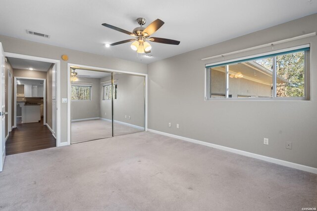 unfurnished bedroom with ceiling fan, light carpet, visible vents, baseboards, and a closet