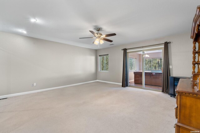 interior space featuring light carpet, ceiling fan, visible vents, and baseboards