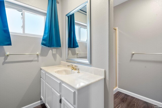 bathroom with vanity, baseboards, and wood finished floors