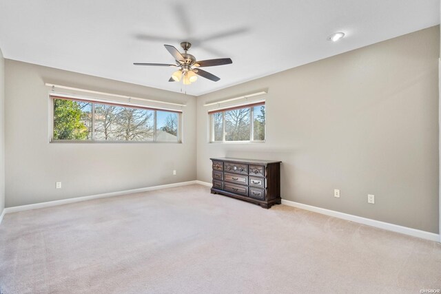 unfurnished bedroom featuring light carpet, ceiling fan, and baseboards