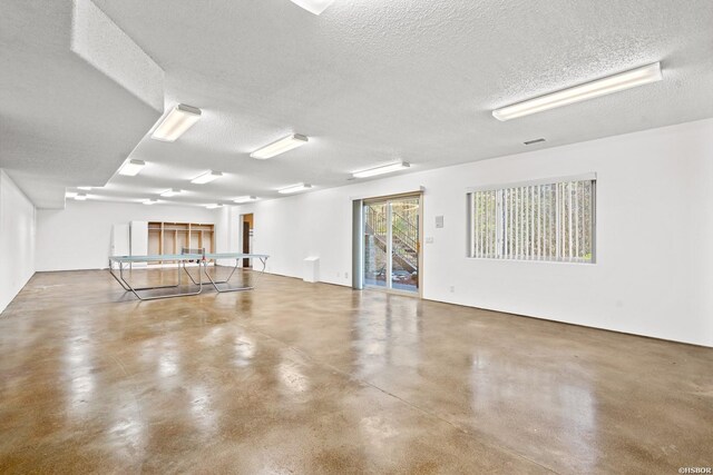 unfurnished room featuring concrete flooring, a textured ceiling, and visible vents