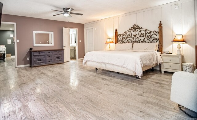 bedroom featuring light wood-style floors, connected bathroom, baseboards, and a ceiling fan