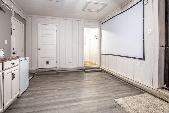 interior space with light wood finished floors and attic access