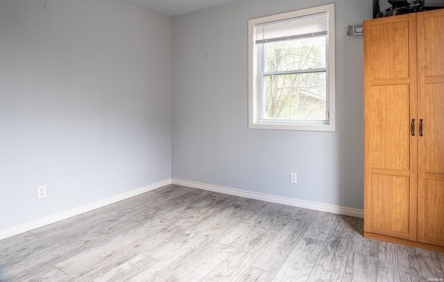 unfurnished bedroom featuring light wood-style flooring and baseboards