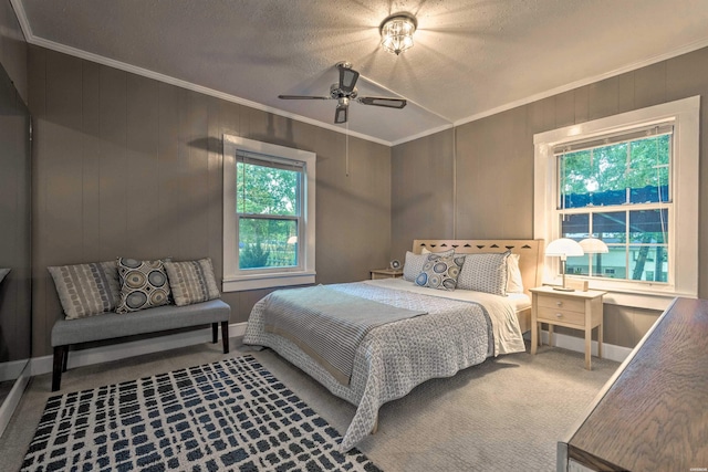 carpeted bedroom with a textured ceiling, a ceiling fan, and ornamental molding