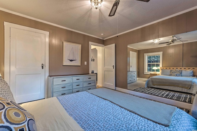 carpeted bedroom with wooden walls, a textured ceiling, ceiling fan, and crown molding