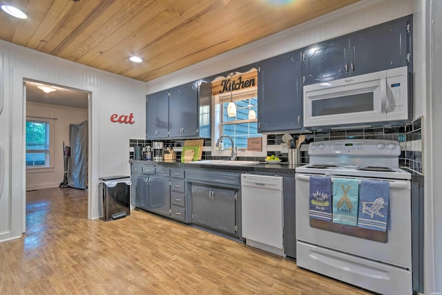 kitchen with white appliances, wood ceiling, dark countertops, a sink, and crown molding