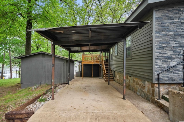 view of car parking featuring driveway, stairway, a carport, and a storage unit