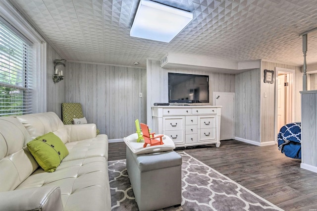 living room featuring wood walls, wood finished floors, and baseboards