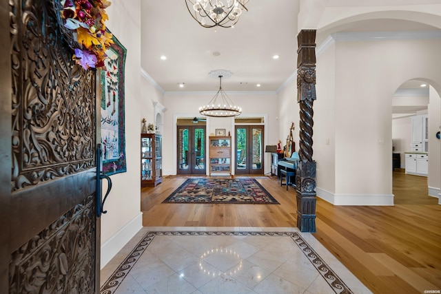 foyer entrance with baseboards, french doors, wood finished floors, and ornamental molding