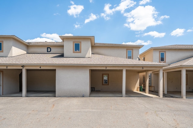 view of front of property with roof with shingles and stucco siding