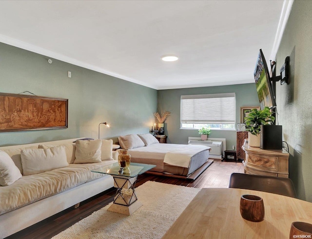 bedroom with ornamental molding and wood finished floors