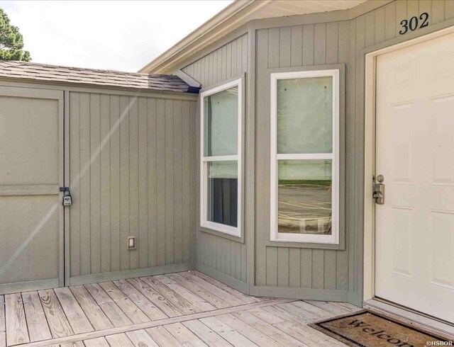 property entrance featuring a shingled roof