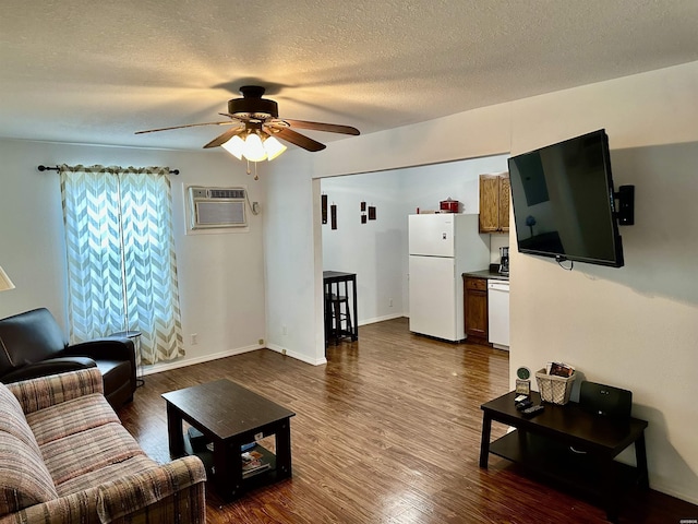 living room with baseboards, dark wood-style floors, ceiling fan, a textured ceiling, and a wall mounted AC