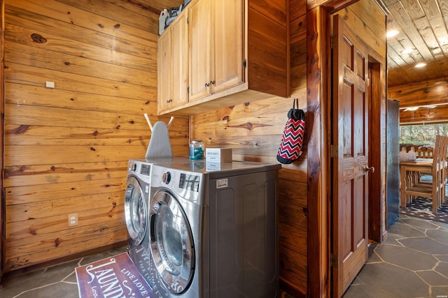 laundry area featuring wooden ceiling, cabinet space, independent washer and dryer, and wood walls