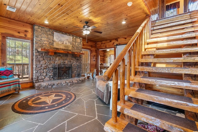 living area featuring visible vents, stairway, wood walls, and wood ceiling