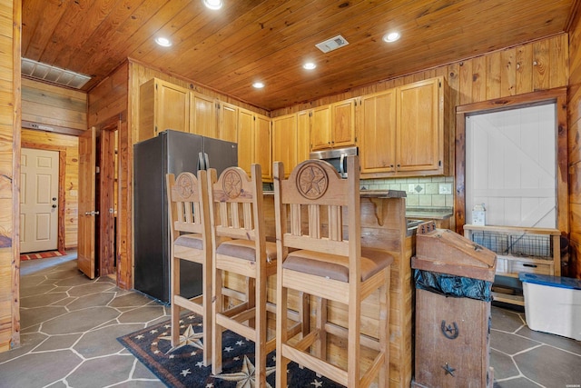 kitchen with wooden walls, visible vents, wooden ceiling, appliances with stainless steel finishes, and recessed lighting