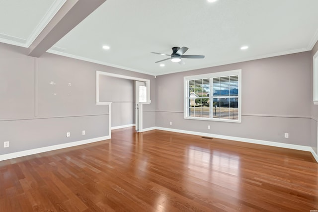 empty room featuring ceiling fan, wood finished floors, visible vents, baseboards, and ornamental molding