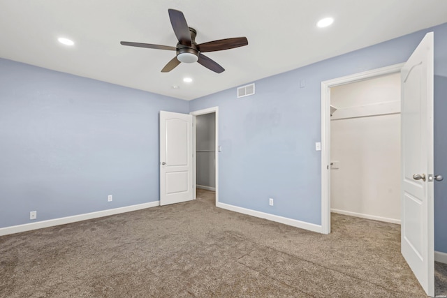 unfurnished bedroom featuring recessed lighting, carpet flooring, visible vents, baseboards, and a walk in closet