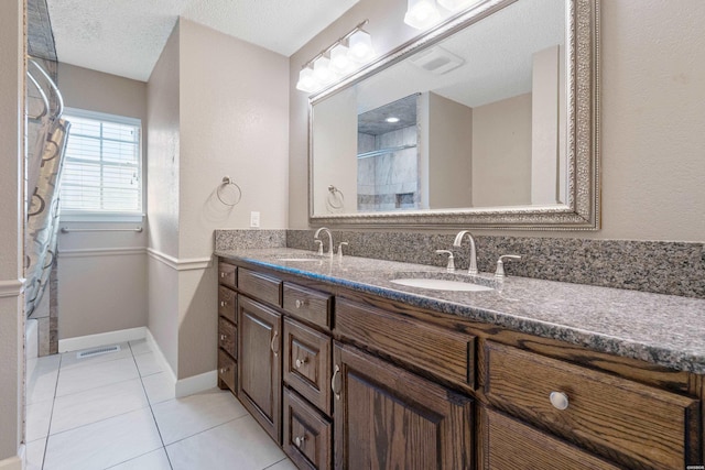 bathroom with double vanity, curtained shower, tile patterned flooring, and a sink