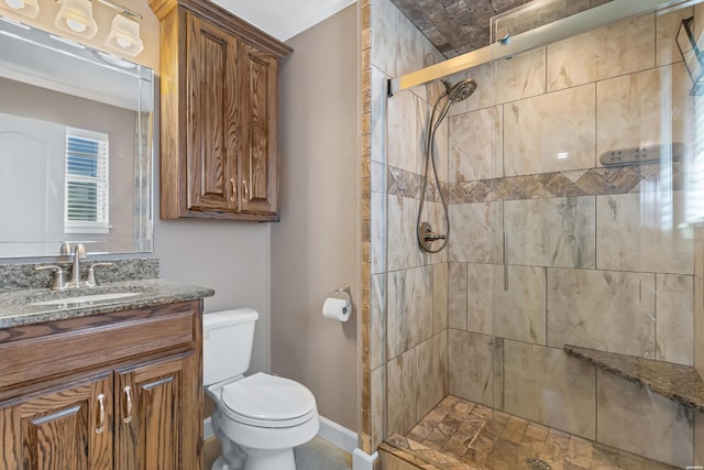 bathroom featuring baseboards, toilet, crown molding, vanity, and a shower stall