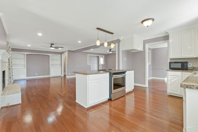 kitchen featuring electric stove, white cabinets, ceiling fan, a tile fireplace, and black microwave