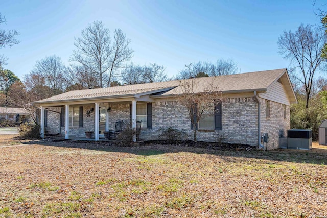 ranch-style house with covered porch, a front yard, and brick siding