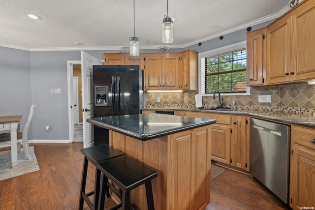 kitchen featuring dark wood-style floors, a center island, crown molding, and stainless steel dishwasher